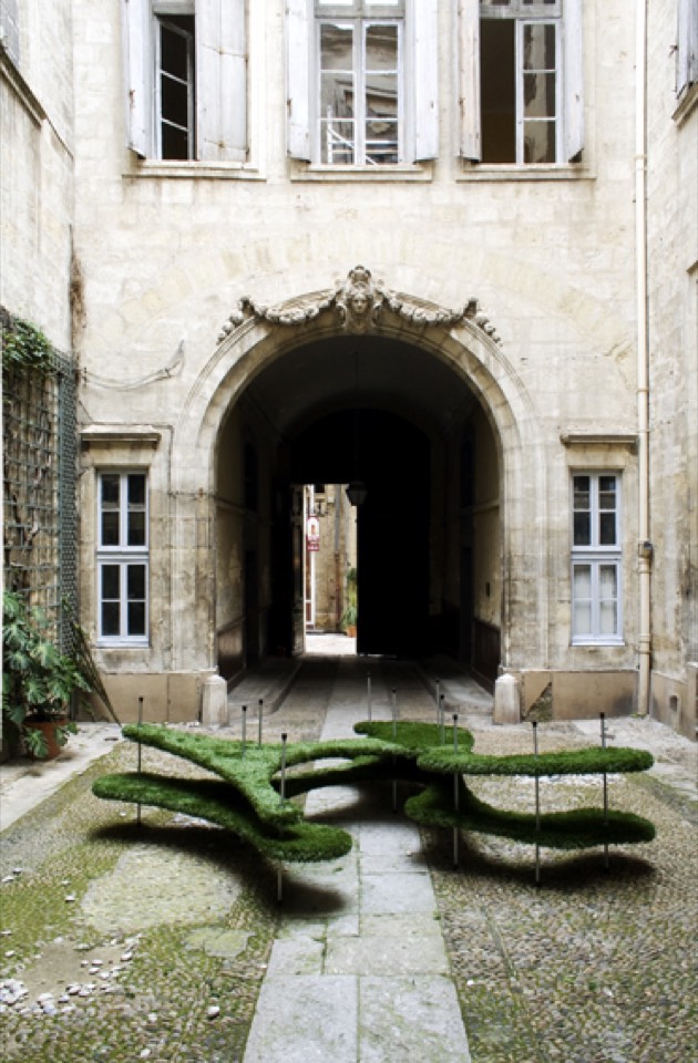 Two layers of artificial turf supported by metal pole in the center of the courtyard.