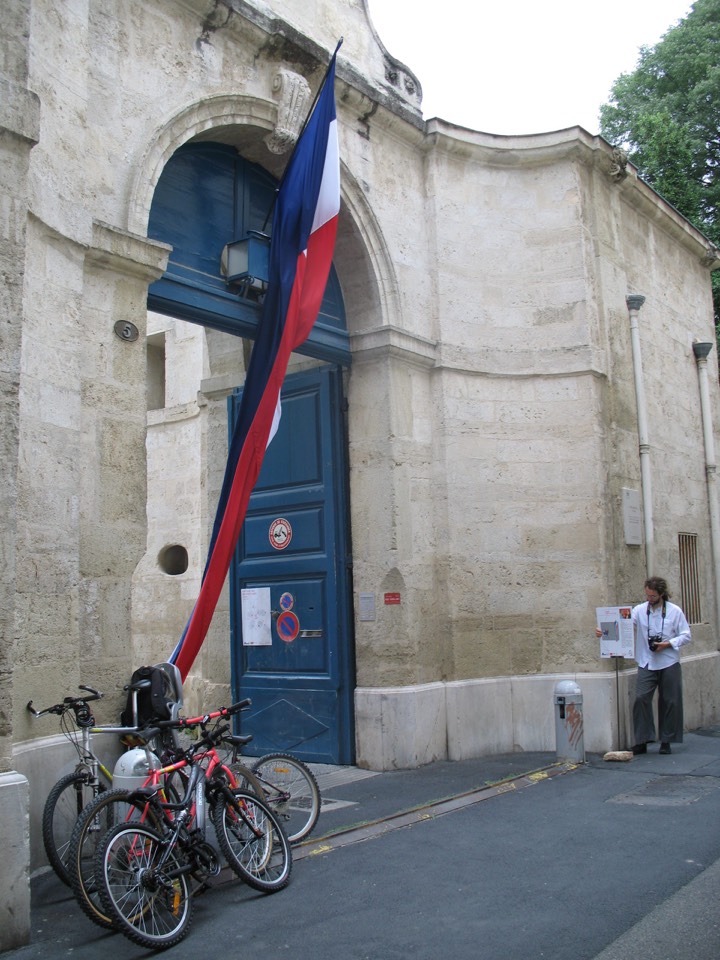 Red, white and blue fabric stemming from the french flag and flowing into the courtyard.