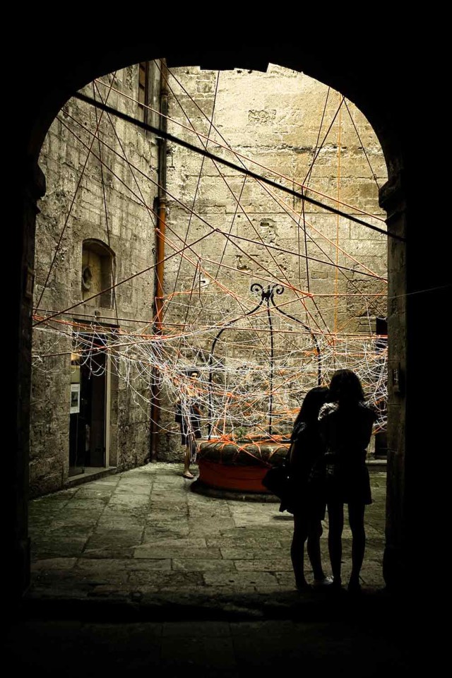 White and red ropes woven and suspended from the elements in the courtyard.