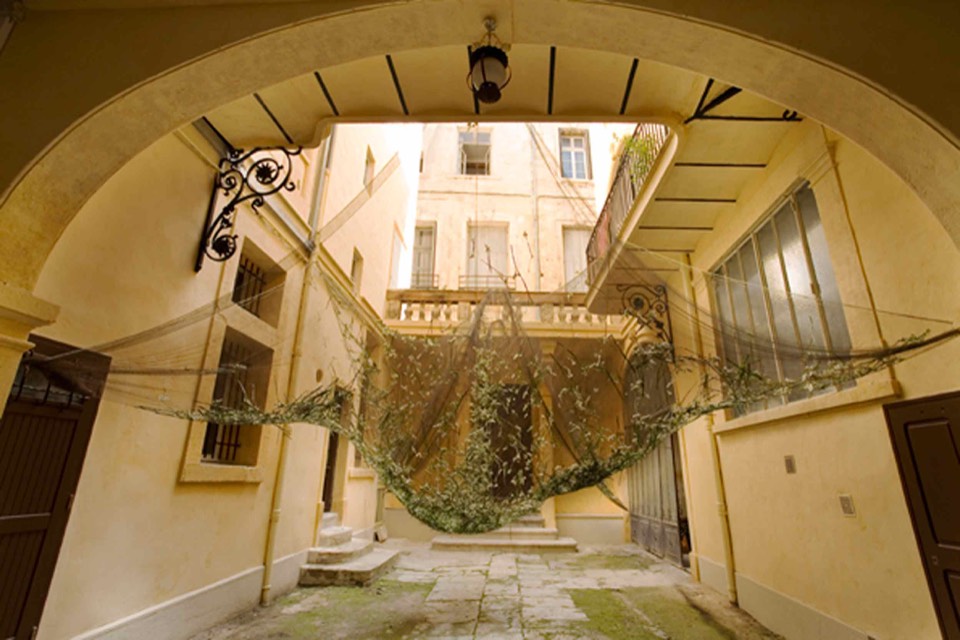 Fabric netting dusted with flowers hanging in the courtyard.