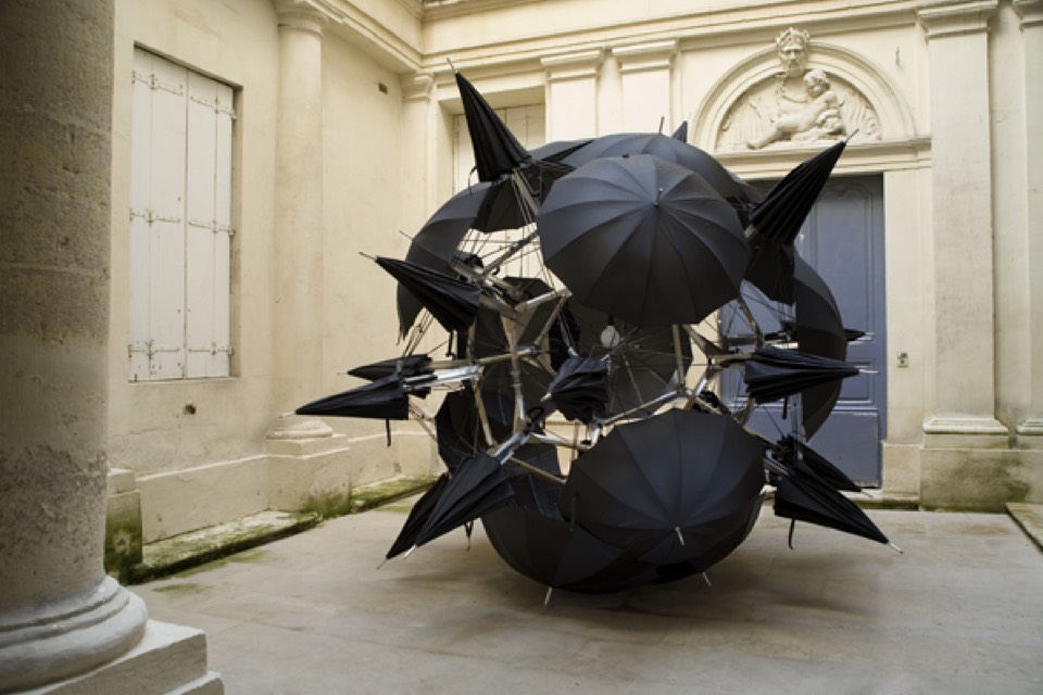 Black umbrellas assembled into a sphere in the center of the courtyard.
